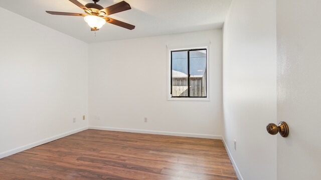 spare room with ceiling fan and dark wood-type flooring