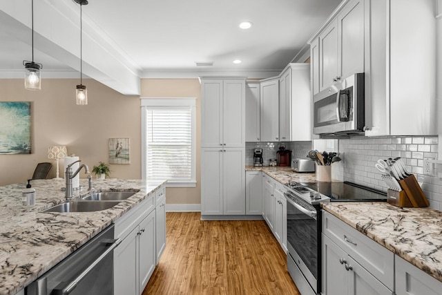 kitchen featuring tasteful backsplash, stainless steel appliances, sink, light hardwood / wood-style flooring, and white cabinets