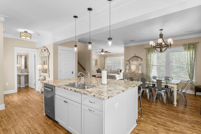 kitchen with ceiling fan with notable chandelier, sink, light wood-type flooring, an island with sink, and white cabinetry