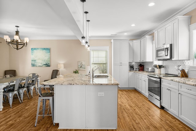 kitchen featuring appliances with stainless steel finishes, a center island with sink, white cabinetry, and sink