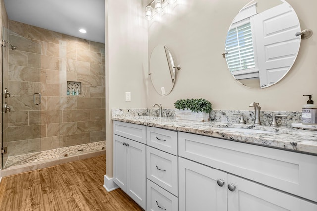 bathroom featuring hardwood / wood-style floors, vanity, and walk in shower