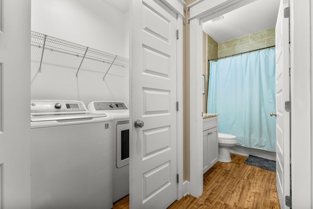 washroom with independent washer and dryer and light wood-type flooring