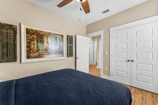 bedroom featuring ceiling fan, a closet, and light wood-type flooring