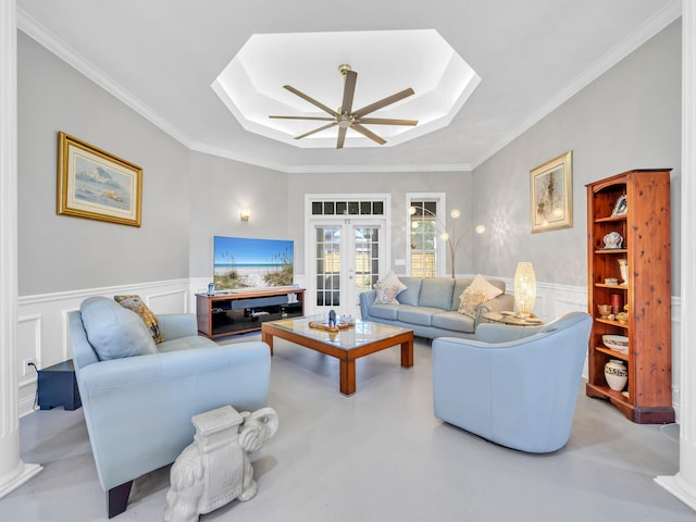 living room with french doors, a tray ceiling, ceiling fan, and ornamental molding