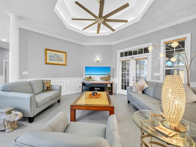 living room featuring ceiling fan, decorative columns, ornamental molding, and french doors