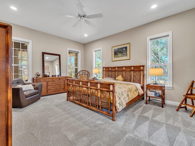 carpeted bedroom featuring multiple windows and ceiling fan