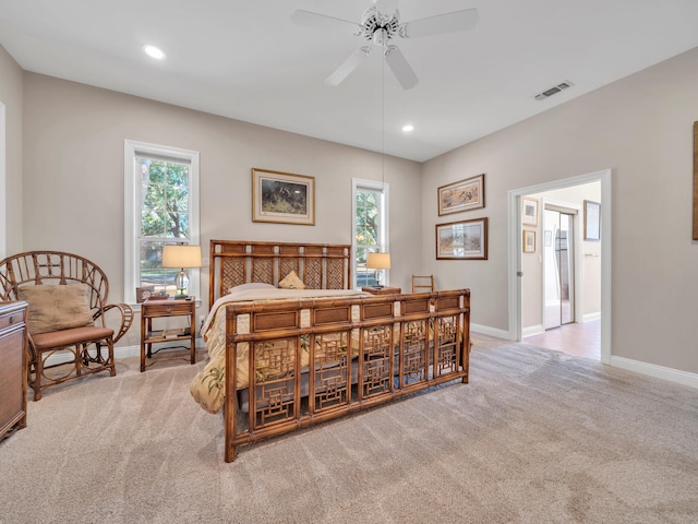 bedroom with ceiling fan, light colored carpet, and multiple windows