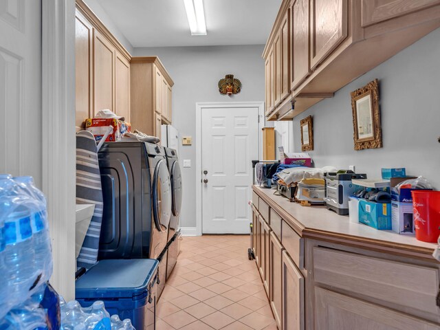 washroom with cabinets, washer and clothes dryer, and light tile patterned flooring