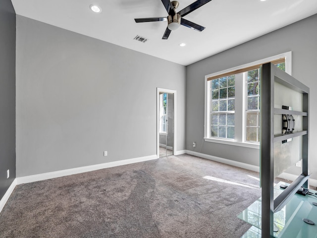 empty room with ceiling fan and light colored carpet