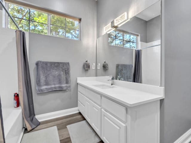 bathroom featuring vanity, wood-type flooring, and shower / bathtub combination with curtain