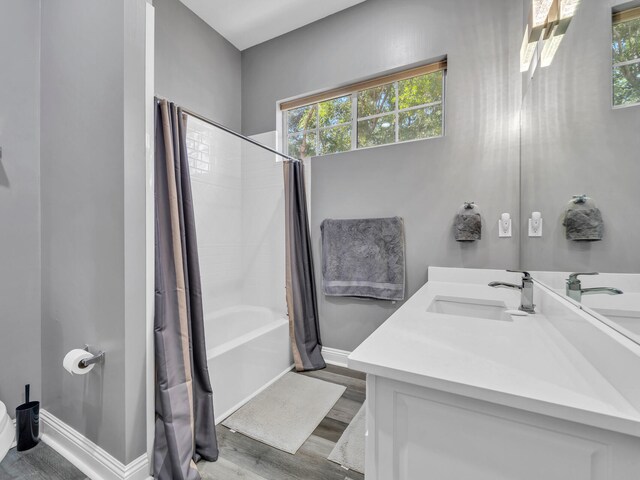 bathroom featuring vanity, hardwood / wood-style flooring, shower / tub combo with curtain, and plenty of natural light