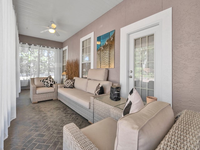 sunroom / solarium featuring ceiling fan