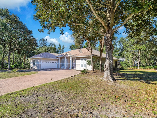 ranch-style home featuring a garage and a front lawn