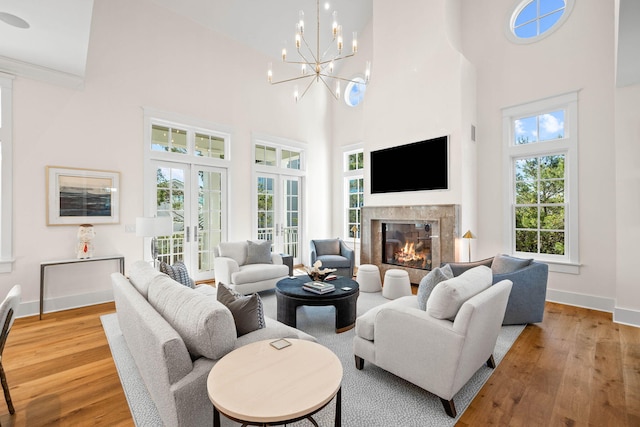 living room with plenty of natural light, a towering ceiling, and light hardwood / wood-style flooring