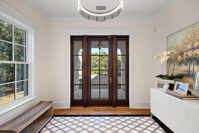 foyer entrance with hardwood / wood-style flooring and ornamental molding