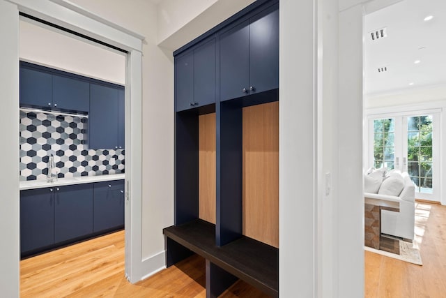 mudroom with hardwood / wood-style floors and sink