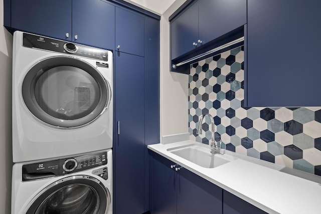 washroom with stacked washer and dryer, cabinets, and sink