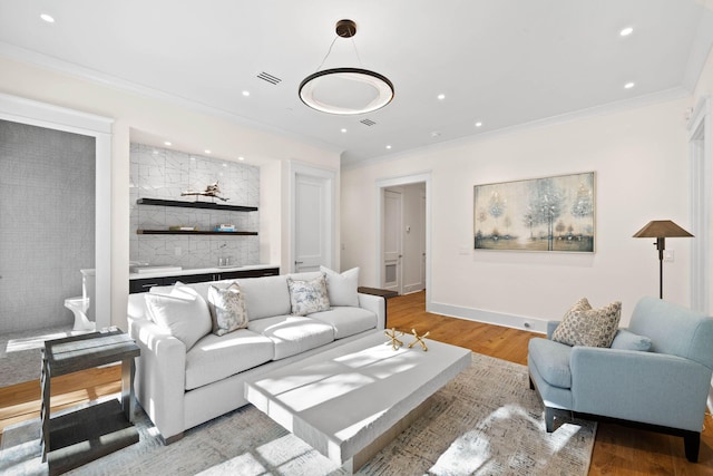 living room with crown molding and light hardwood / wood-style floors