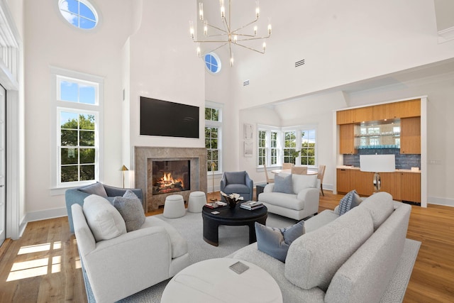 living room with a chandelier, wood-type flooring, and a high ceiling