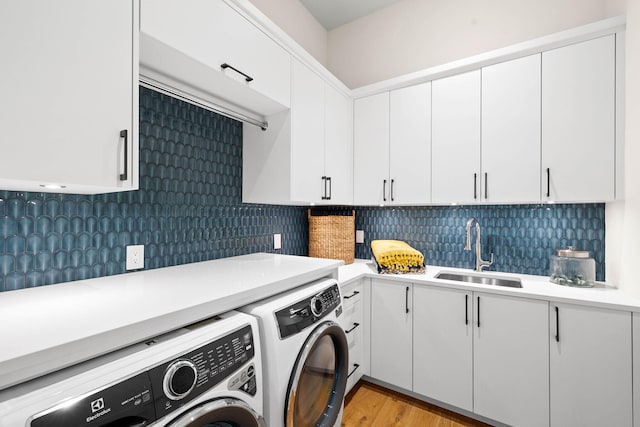 washroom featuring cabinets, light wood-type flooring, separate washer and dryer, and sink