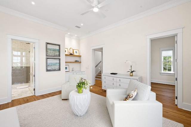 living area with ceiling fan, hardwood / wood-style floors, and ornamental molding