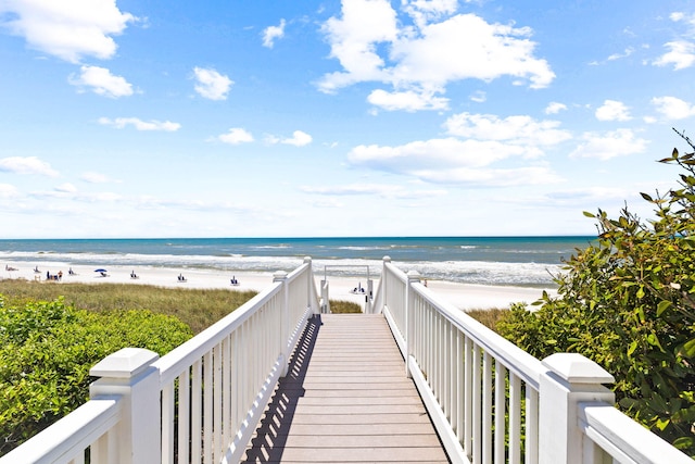 view of property's community featuring a water view and a beach view