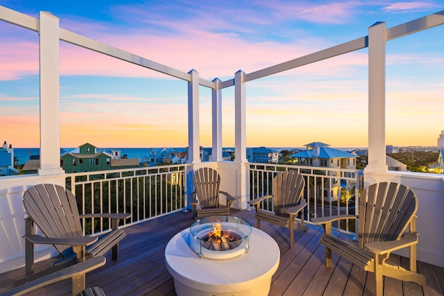 deck at dusk featuring a fire pit