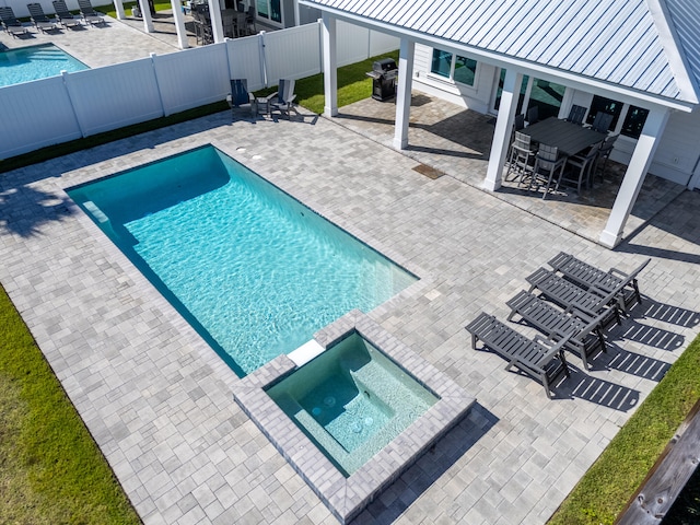 view of swimming pool featuring an in ground hot tub, area for grilling, and a patio area