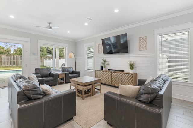 living room with ceiling fan, ornamental molding, and light hardwood / wood-style flooring