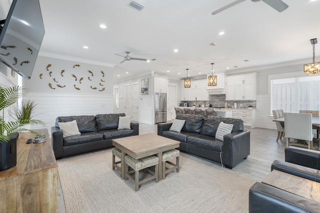 326 E Lakeshore Dr, Panama City Beach, FL 32413 - living room with a ceiling fan, recessed lighting, wainscoting, light wood-style floors, and crown molding