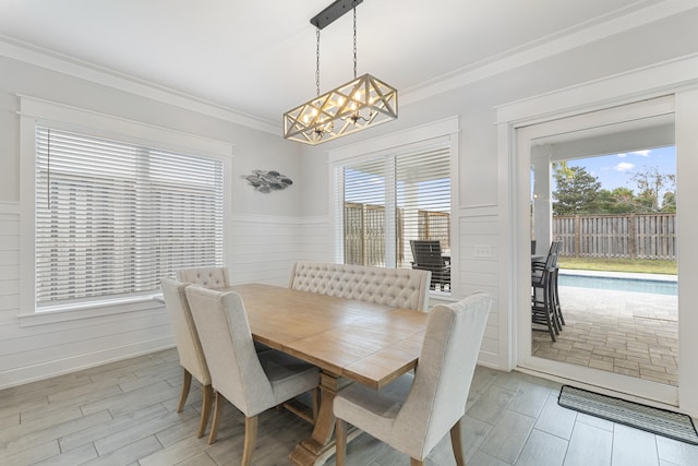 326 E Lakeshore Dr, Panama City Beach, FL 32413 - dining space featuring a chandelier, ornamental molding, wainscoting, and light wood-style floors