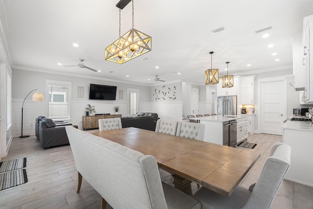 326 E Lakeshore Dr, Panama City Beach, FL 32413 - dining room with a chandelier, a ceiling fan, recessed lighting, a wainscoted wall, and crown molding