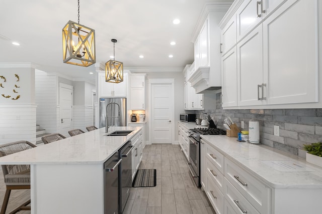 kitchen featuring a kitchen breakfast bar, white cabinets, hanging light fixtures, and appliances with stainless steel finishes