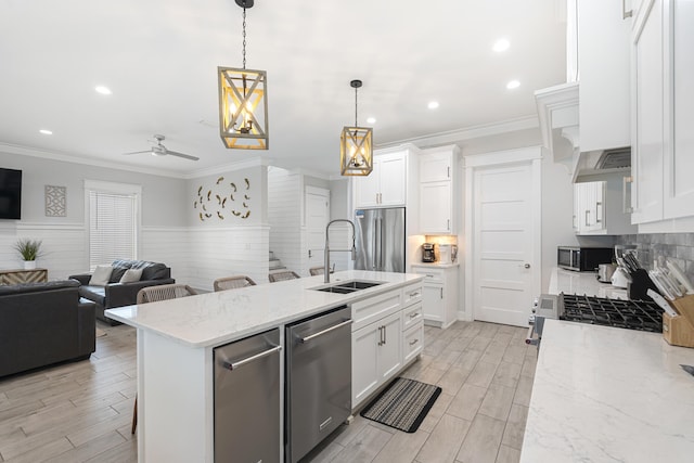 326 E Lakeshore Dr, Panama City Beach, FL 32413 - kitchen with stainless steel appliances, ornamental molding, open floor plan, wainscoting, and white cabinetry