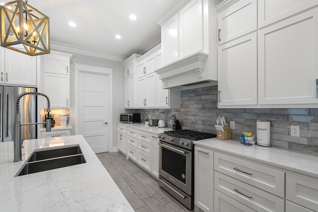 kitchen with high end range, white cabinets, decorative backsplash, light stone countertops, and decorative light fixtures