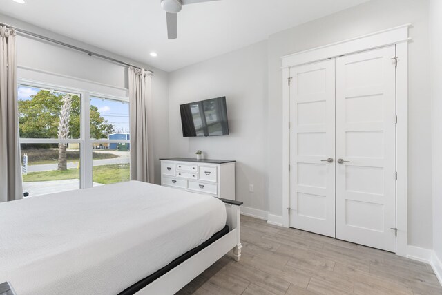 bedroom featuring a closet, light hardwood / wood-style floors, and ceiling fan