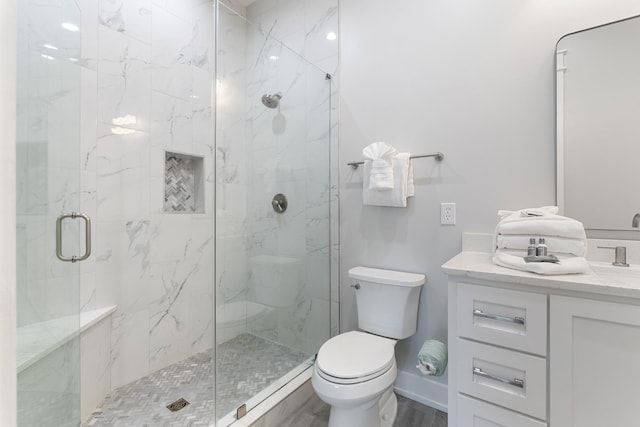 bathroom featuring toilet, an enclosed shower, wood-type flooring, and vanity