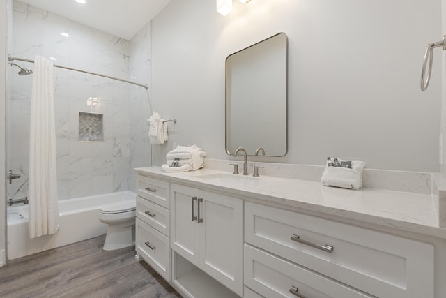 full bathroom featuring hardwood / wood-style flooring, vanity, toilet, and shower / tub combo