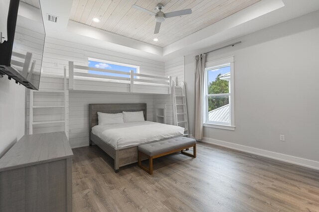 bedroom with hardwood / wood-style floors, a raised ceiling, ceiling fan, and wood ceiling