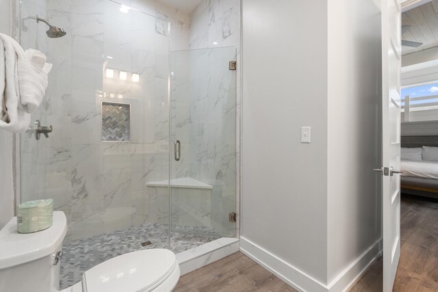 bathroom featuring hardwood / wood-style floors, toilet, and walk in shower