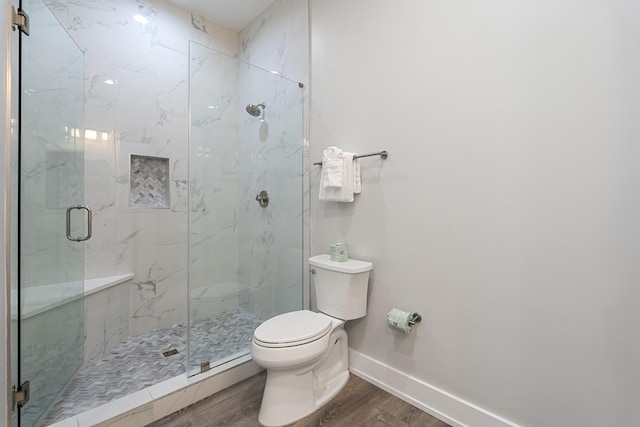 bathroom featuring walk in shower, hardwood / wood-style floors, and toilet