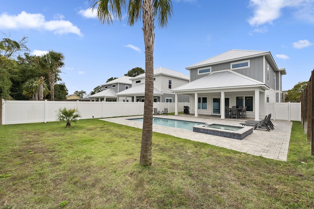 326 E Lakeshore Dr, Panama City Beach, FL 32413 - rear view of property with board and batten siding, a metal roof, a fenced backyard, a patio, and a pool with connected hot tub