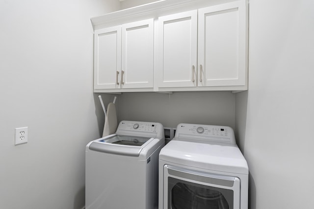 laundry area featuring cabinets and washer and clothes dryer