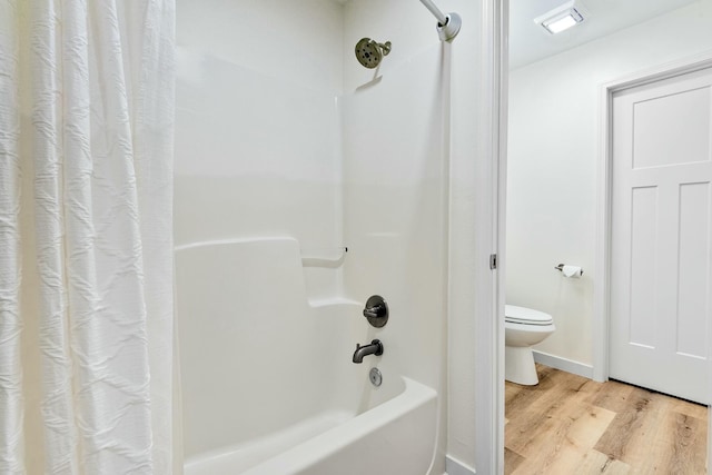 bathroom featuring wood-type flooring, shower / tub combo, and toilet