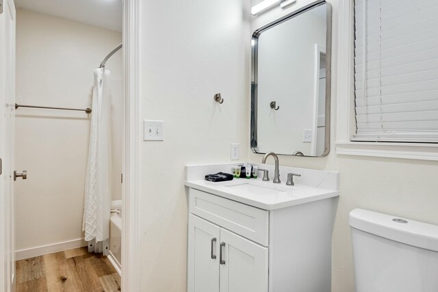 full bathroom with vanity, wood-type flooring, shower / bath combo, and toilet