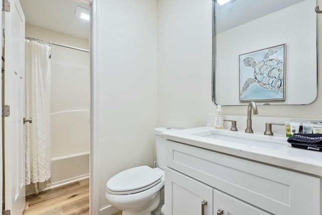 full bathroom featuring hardwood / wood-style floors, vanity, shower / bath combo, and toilet