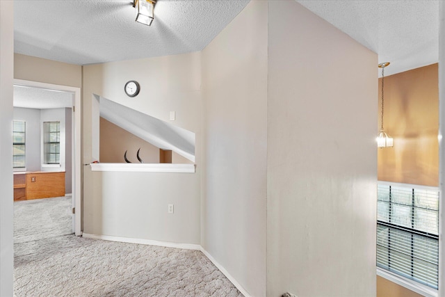 hallway with carpet floors and a textured ceiling