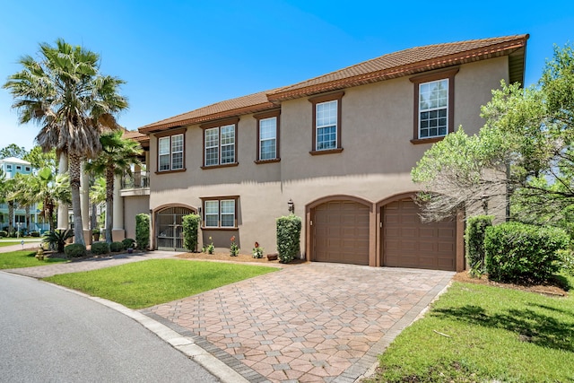 mediterranean / spanish-style home featuring a front yard and a garage