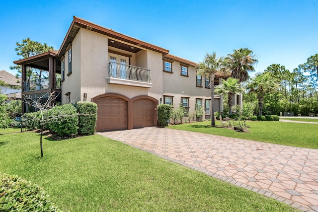 mediterranean / spanish-style home featuring a balcony, a front lawn, and a garage