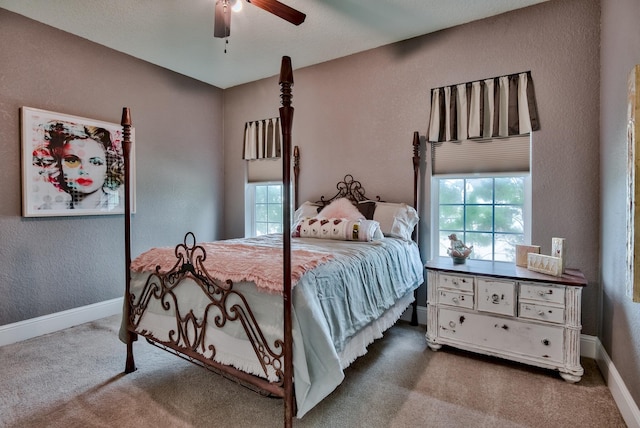 bedroom featuring ceiling fan, carpet floors, and multiple windows